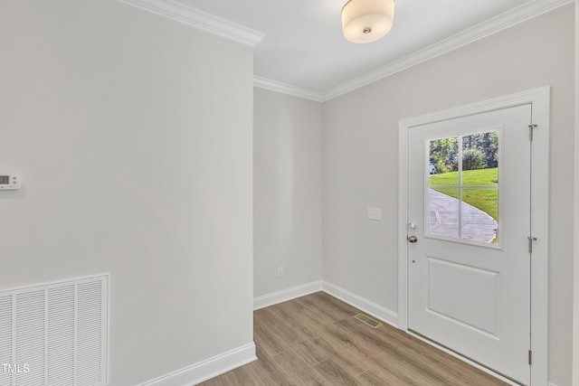 foyer with baseboards, crown molding, light wood-type flooring, and visible vents