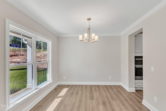 spare room featuring light wood finished floors, a chandelier, baseboards, and ornamental molding