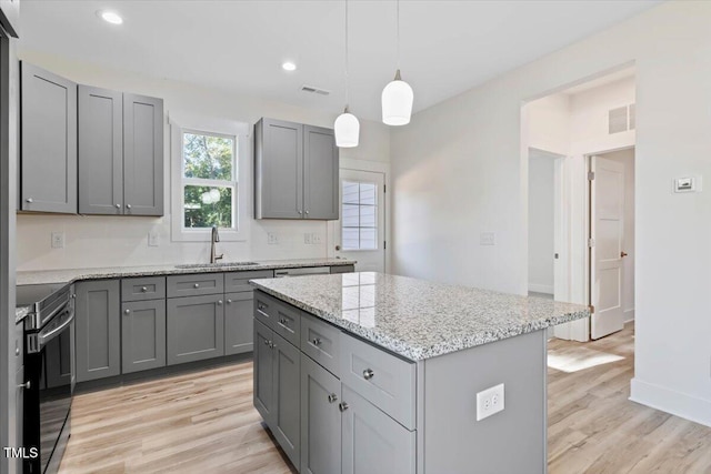 kitchen featuring gray cabinetry, black range with electric stovetop, light wood-type flooring, sink, and a center island