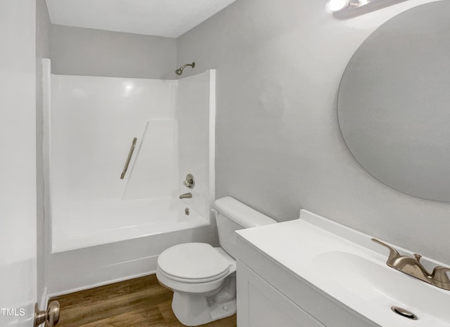 full bathroom featuring hardwood / wood-style floors, washtub / shower combination, toilet, and vanity