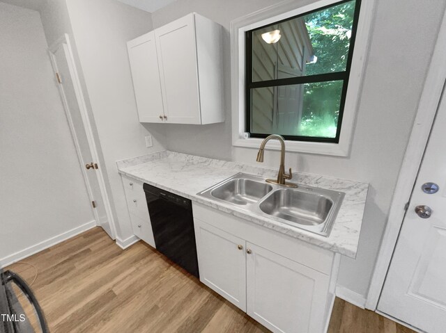 kitchen with sink, white cabinets, light hardwood / wood-style floors, and black dishwasher