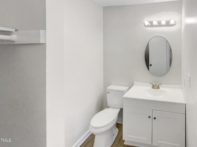 bathroom featuring toilet, vanity, and wood-type flooring