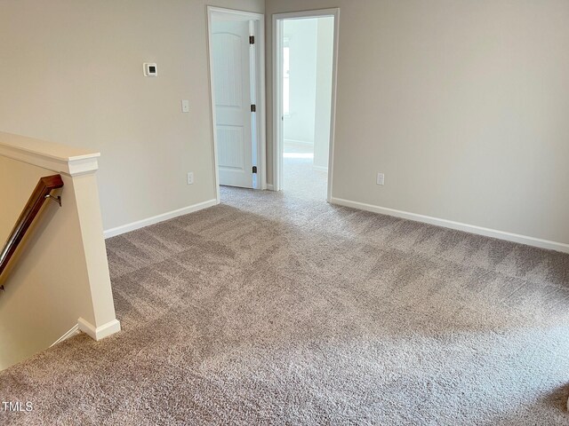 carpeted empty room with baseboards
