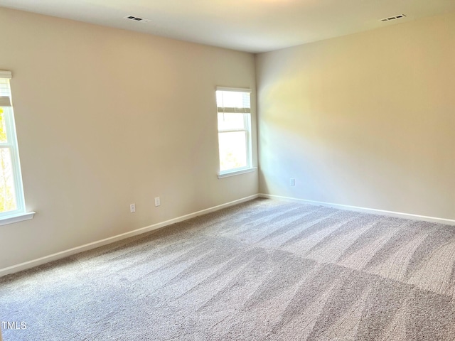 carpeted empty room featuring baseboards