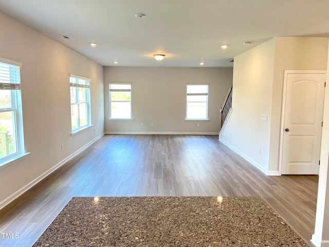 spare room featuring wood finished floors, baseboards, and recessed lighting
