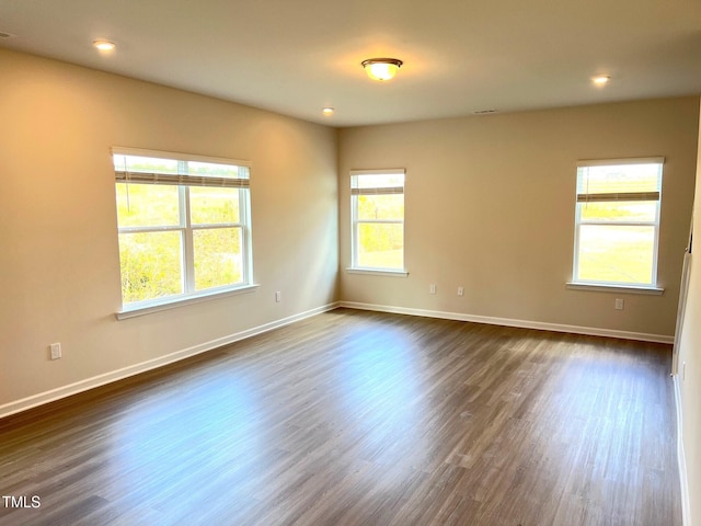 unfurnished room featuring dark wood-type flooring, baseboards, and recessed lighting