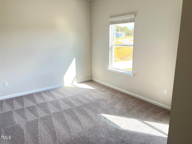 unfurnished room with carpet floors and baseboards