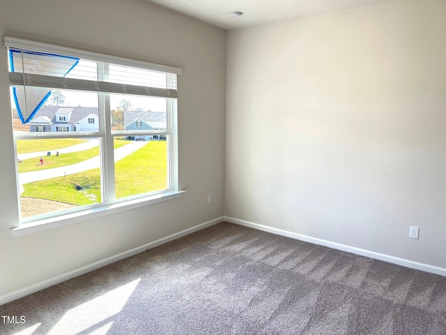 empty room featuring carpet flooring and baseboards