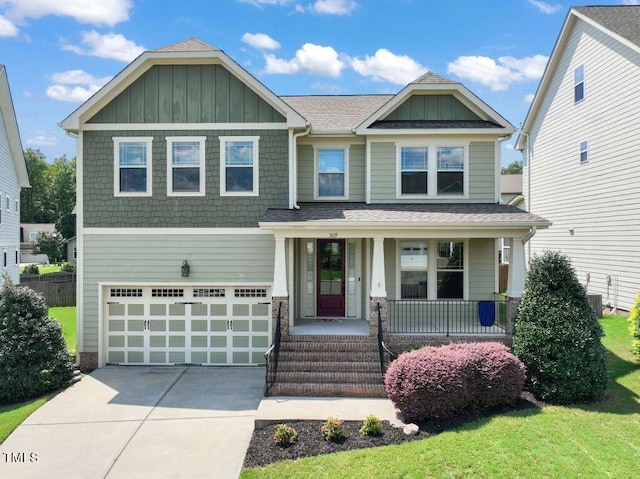 craftsman house featuring a garage, a front yard, central AC, and covered porch