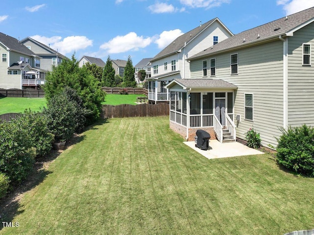 back of house featuring a yard, a sunroom, and a patio area