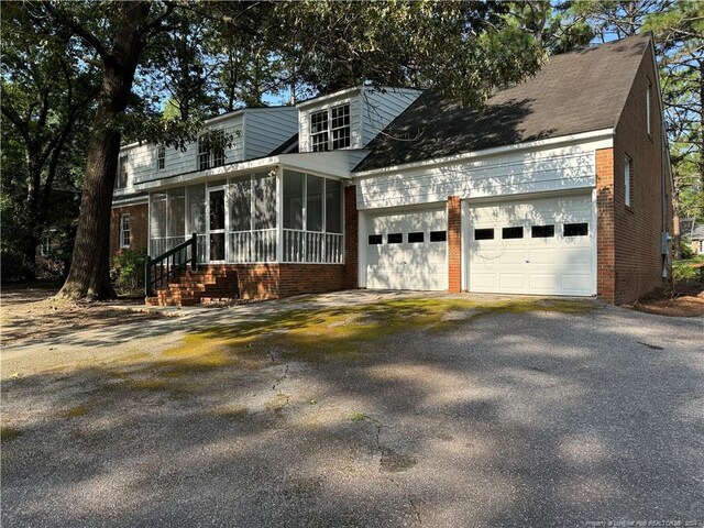 view of front of house featuring a garage and a sunroom