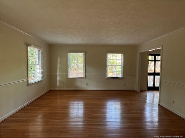 empty room featuring a textured ceiling and hardwood / wood-style floors