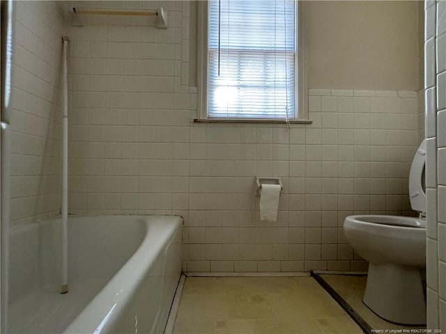 bathroom featuring tile walls, toilet, a tub, and tile patterned floors