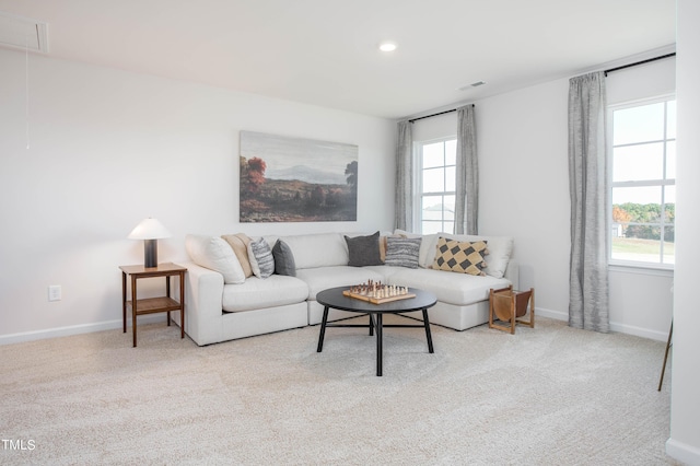 living room with carpet floors, attic access, visible vents, and baseboards