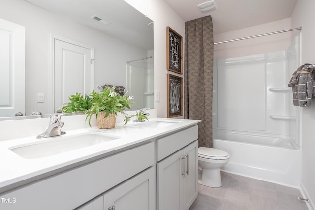 bathroom featuring toilet, double vanity, visible vents, and a sink