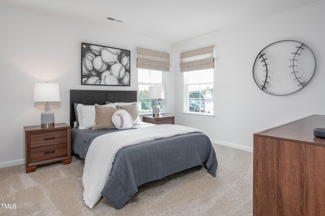 bedroom with baseboards, visible vents, and light colored carpet