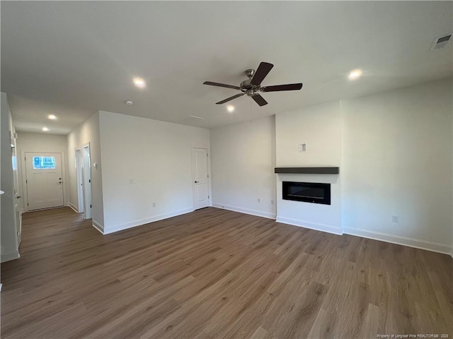 unfurnished living room with ceiling fan and wood-type flooring