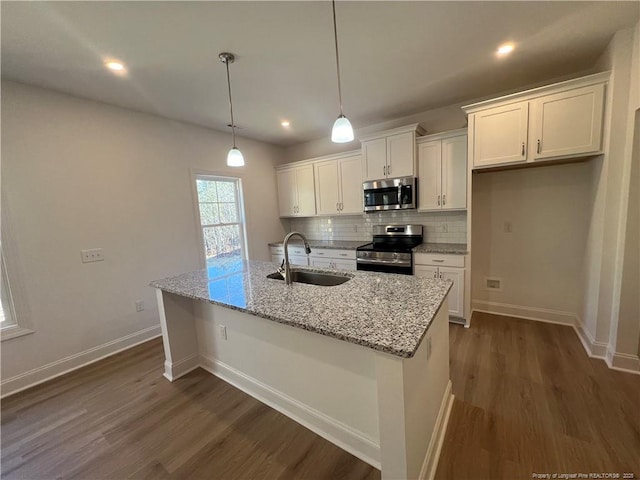 kitchen with sink, decorative light fixtures, an island with sink, stainless steel appliances, and white cabinets