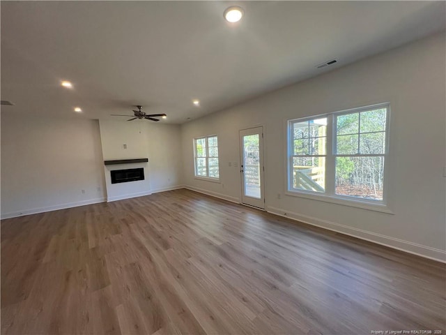 unfurnished living room with ceiling fan and light hardwood / wood-style flooring