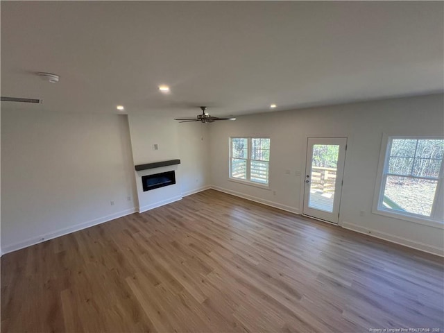 unfurnished living room featuring ceiling fan and light wood-type flooring