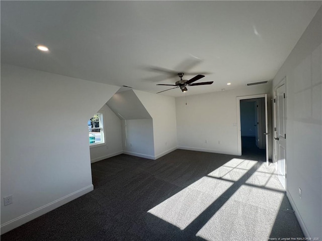 additional living space with lofted ceiling, ceiling fan, and dark colored carpet