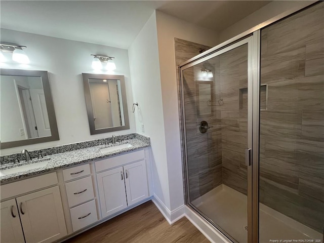 bathroom with walk in shower, vanity, and hardwood / wood-style flooring