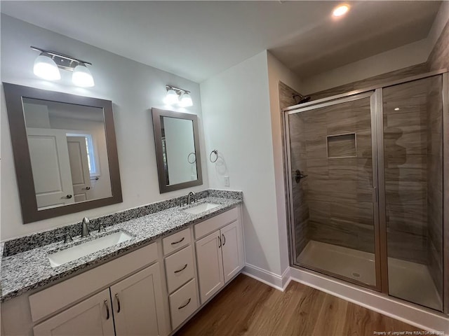 bathroom featuring vanity, hardwood / wood-style flooring, and a shower with door