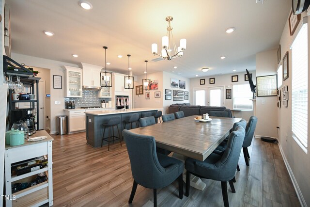 dining area featuring wood-type flooring and a chandelier