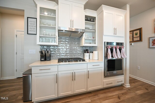 kitchen with white cabinetry, dark hardwood / wood-style floors, appliances with stainless steel finishes, and backsplash