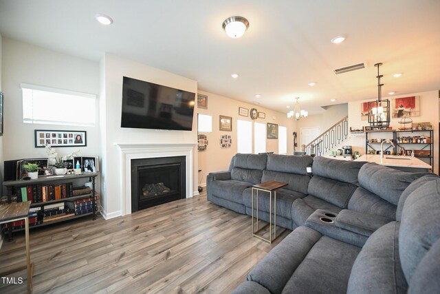 living room with an inviting chandelier, hardwood / wood-style floors, and a healthy amount of sunlight