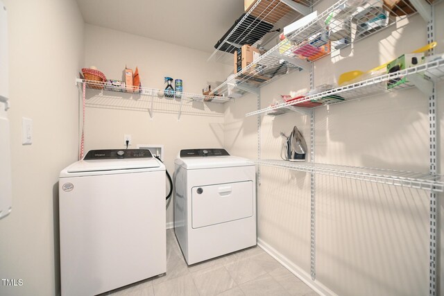 laundry room featuring light tile patterned flooring and washer and clothes dryer