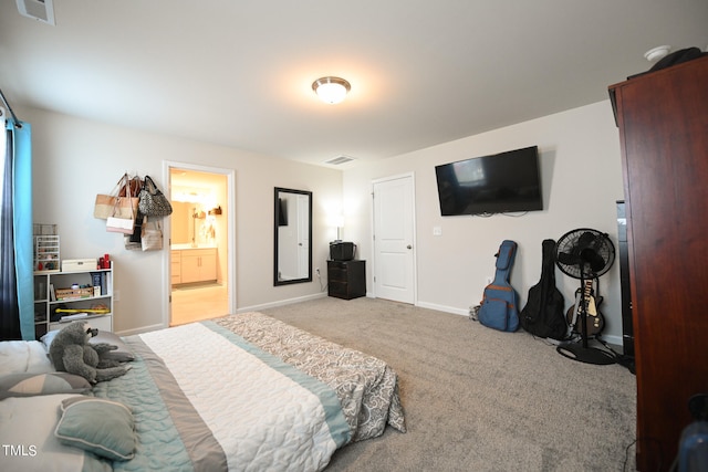 bedroom with connected bathroom and light carpet