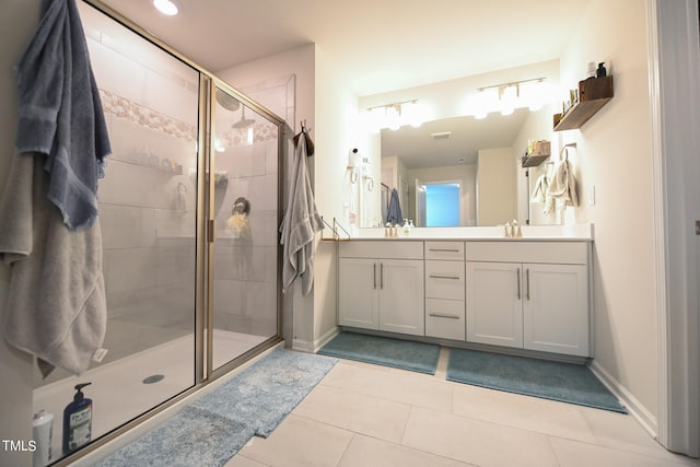 bathroom with tile patterned flooring, a shower with door, and dual bowl vanity