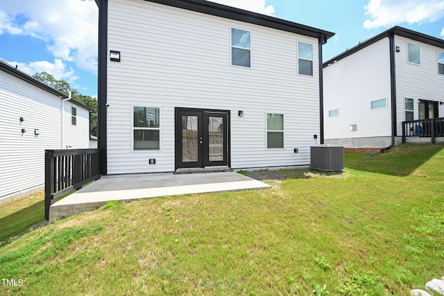 rear view of property with cooling unit, a yard, a patio area, and french doors