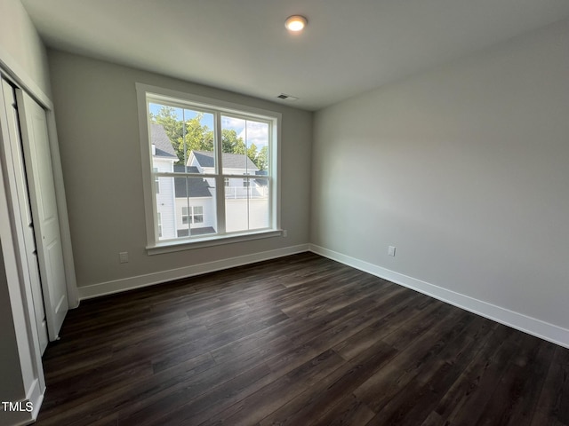 unfurnished bedroom featuring dark hardwood / wood-style flooring and a closet