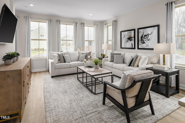 living room with a wealth of natural light and light hardwood / wood-style flooring