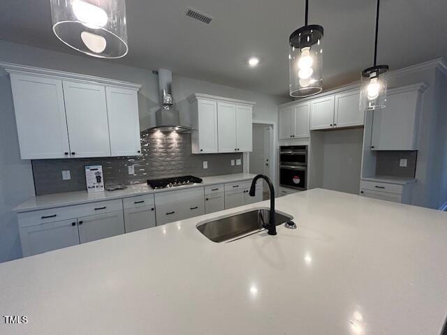 kitchen featuring white cabinets, sink, tasteful backsplash, decorative light fixtures, and gas cooktop