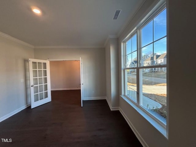 unfurnished room featuring dark hardwood / wood-style flooring, crown molding, plenty of natural light, and french doors