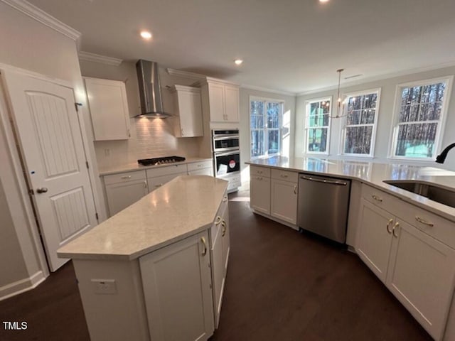 kitchen featuring appliances with stainless steel finishes, wall chimney range hood, decorative light fixtures, a center island, and dark hardwood / wood-style floors