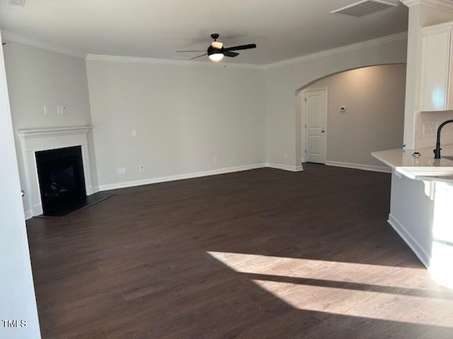 unfurnished living room featuring dark hardwood / wood-style floors and crown molding