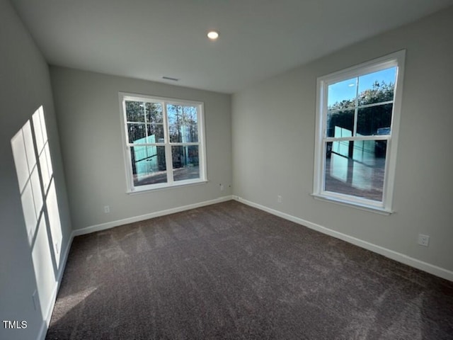 empty room with plenty of natural light and dark carpet