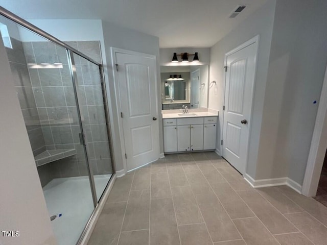 bathroom with tile patterned floors, vanity, and a shower with shower door