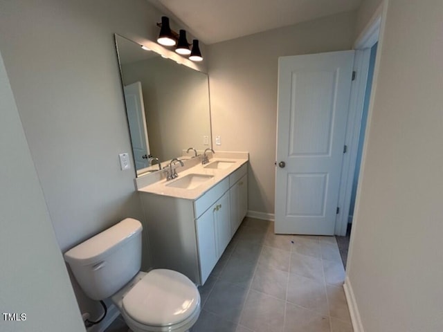 bathroom with tile patterned flooring, vanity, and toilet