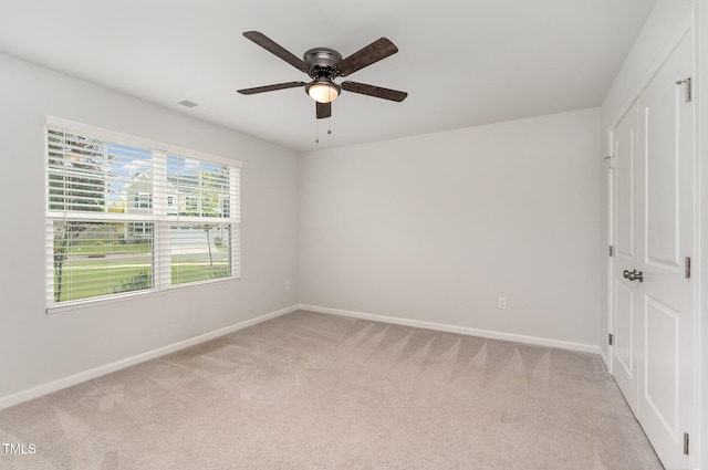 spare room featuring ceiling fan and light carpet