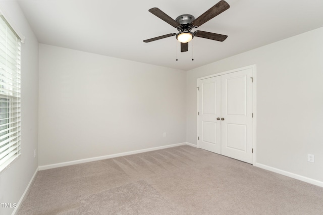 unfurnished bedroom with ceiling fan, carpet, and multiple windows