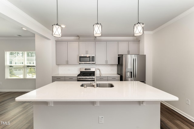 kitchen with appliances with stainless steel finishes, a center island with sink, sink, and tasteful backsplash