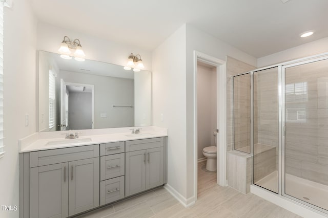 bathroom featuring a shower with shower door, toilet, tile patterned flooring, and vanity