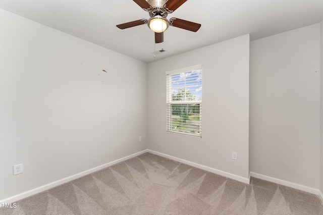 carpeted spare room featuring ceiling fan