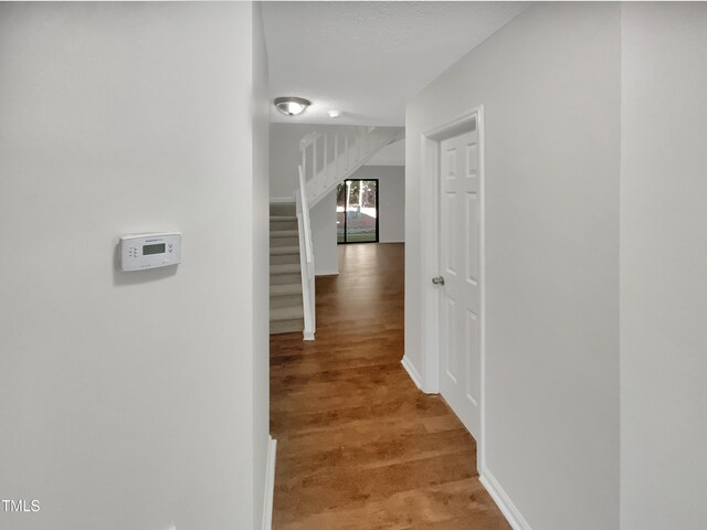 corridor with hardwood / wood-style flooring