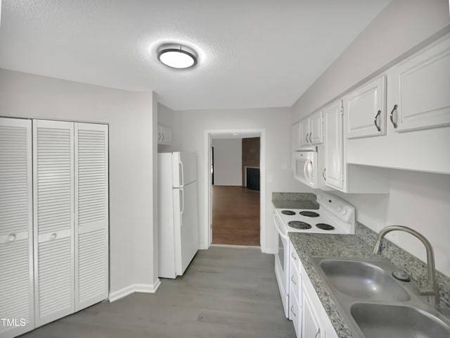 kitchen featuring white appliances, light hardwood / wood-style flooring, sink, a textured ceiling, and white cabinets